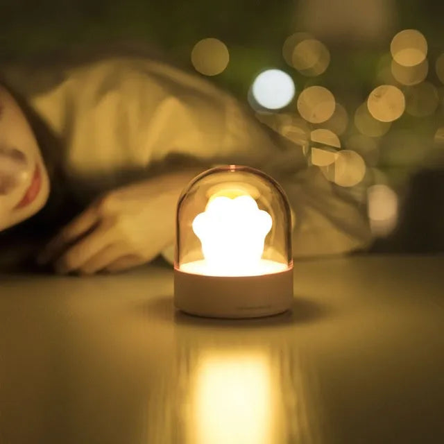 Grey and pink cat paw shaped USB rechargeable night light with music box function on desktop