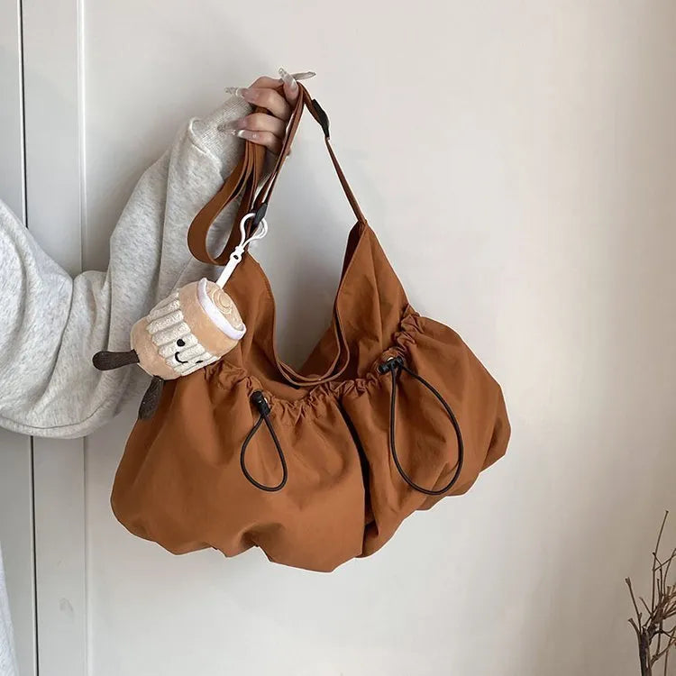 Soft green pleated polyester crossbody bag with a split pocket, shown folded and open with phone pocket visible.