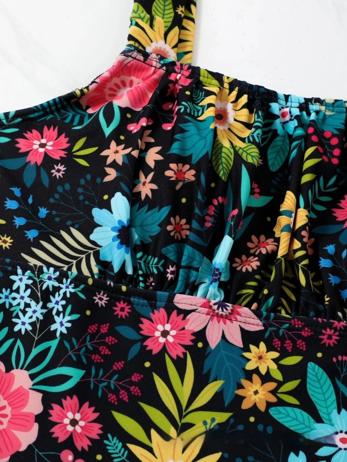 Women's pastoral style floral print one-piece swimsuit on a hanger, showing front design.