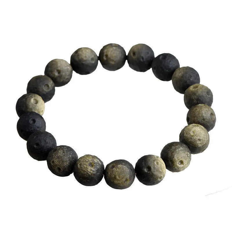Close-up of a natural obsidian crater ball bracelet with grinding-treated beads on a wrist.