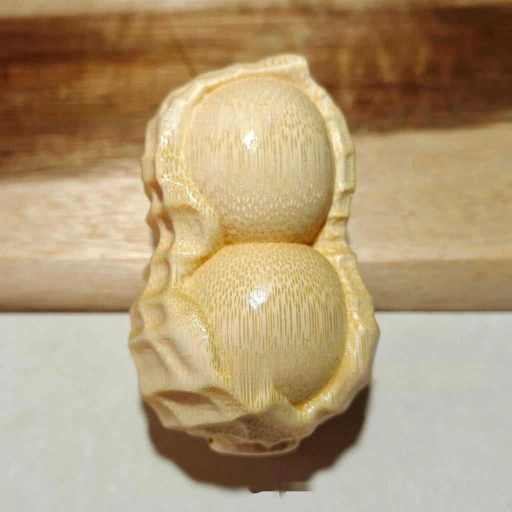 Solid bamboo peanut ornament carving on a plain background