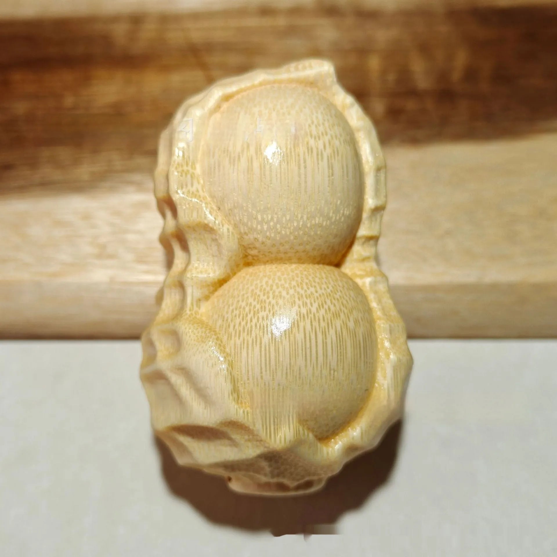 Solid bamboo peanut ornament carving on a plain background