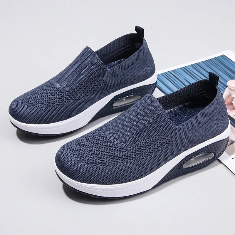 Women's black mesh running shoes with air cushion sole and round toe on a grey background.