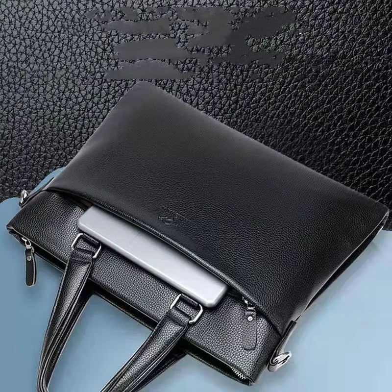 Men's black PU leather shoulder messenger bag with splicing design on a table.