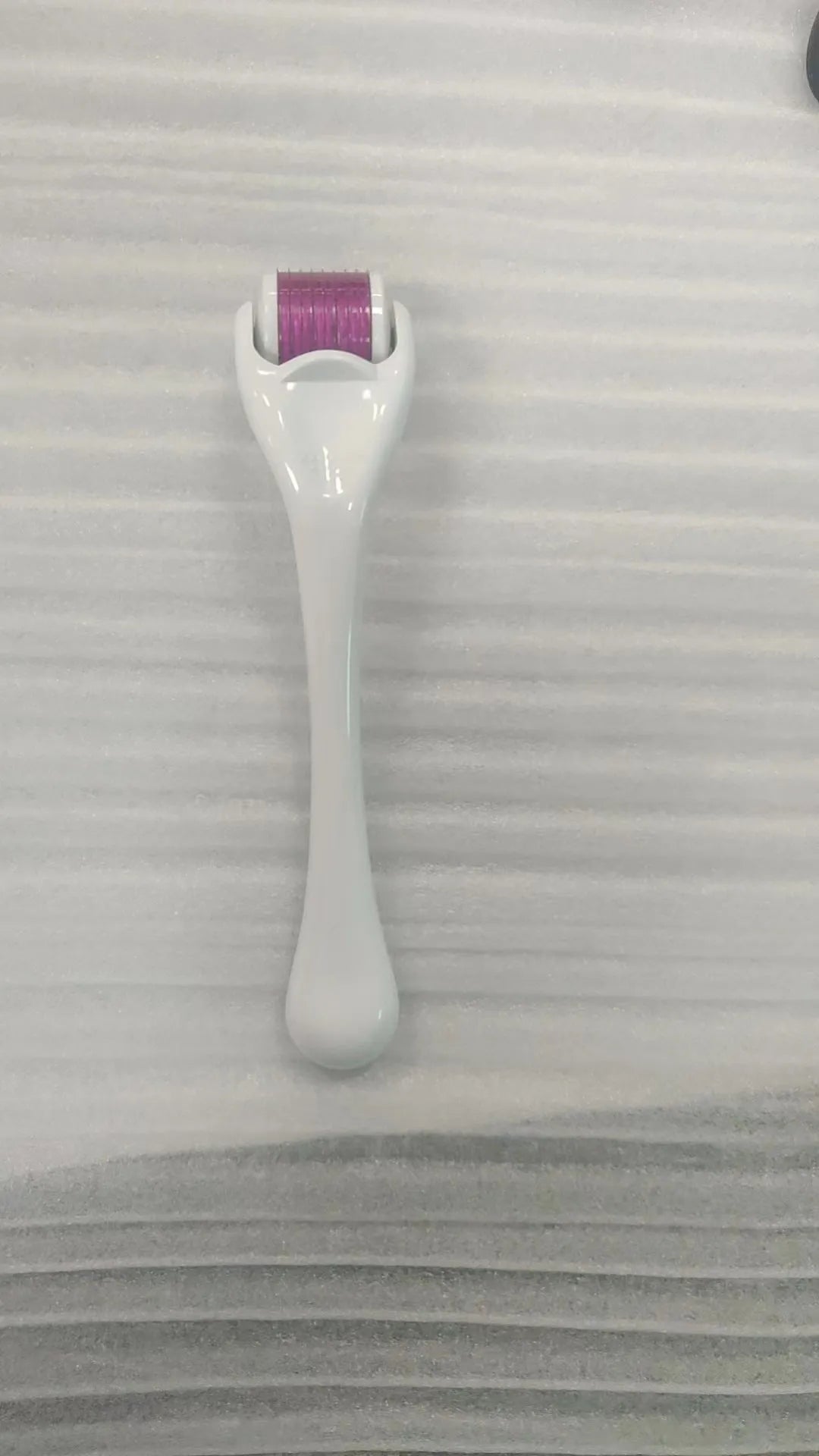 Sterile 540 micro needle derma roller showing handle and needle wheel in assorted colours.