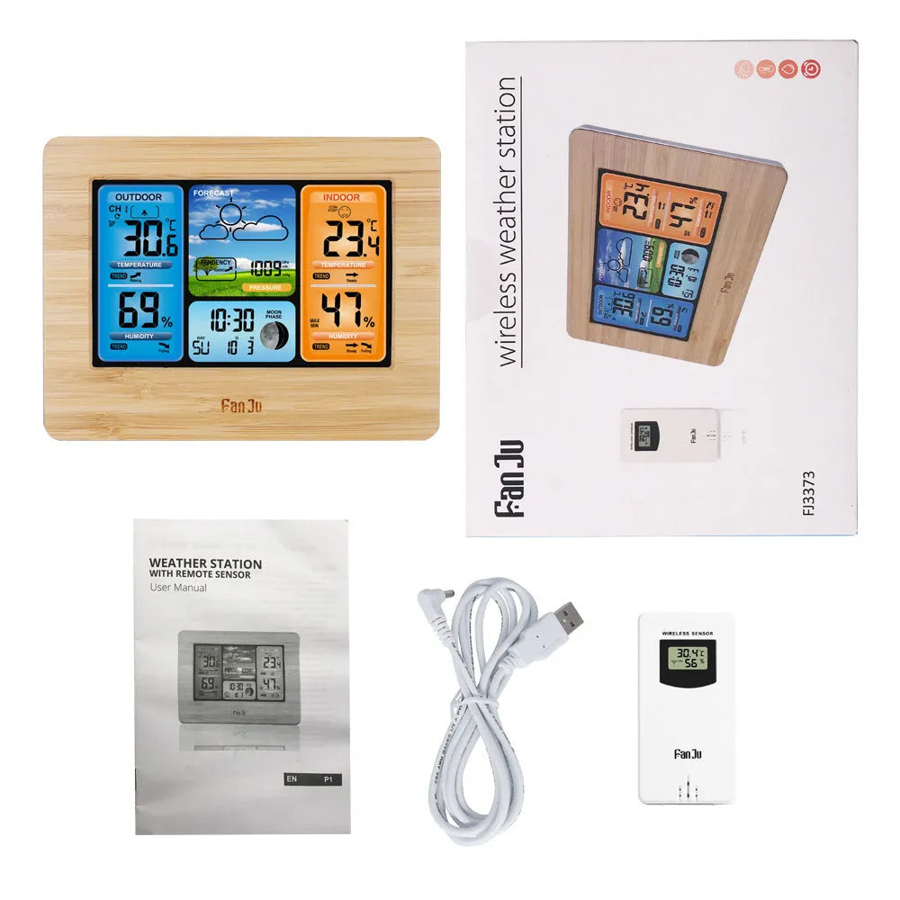 Black rectangular LCD digital weather station displaying temperature, humidity, pressure, and time on a desk.