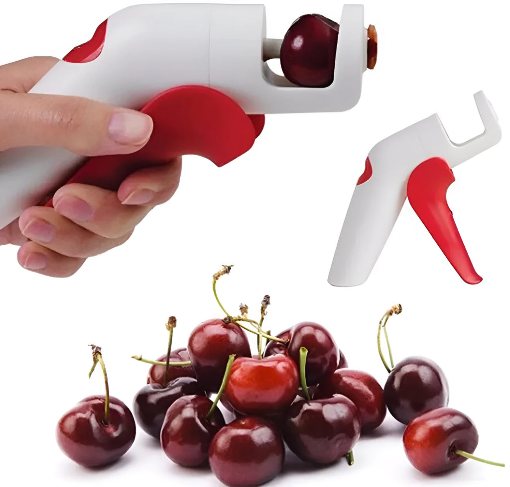 Stainless steel manual cherry pitting tool with ergonomic handle on a wooden surface.