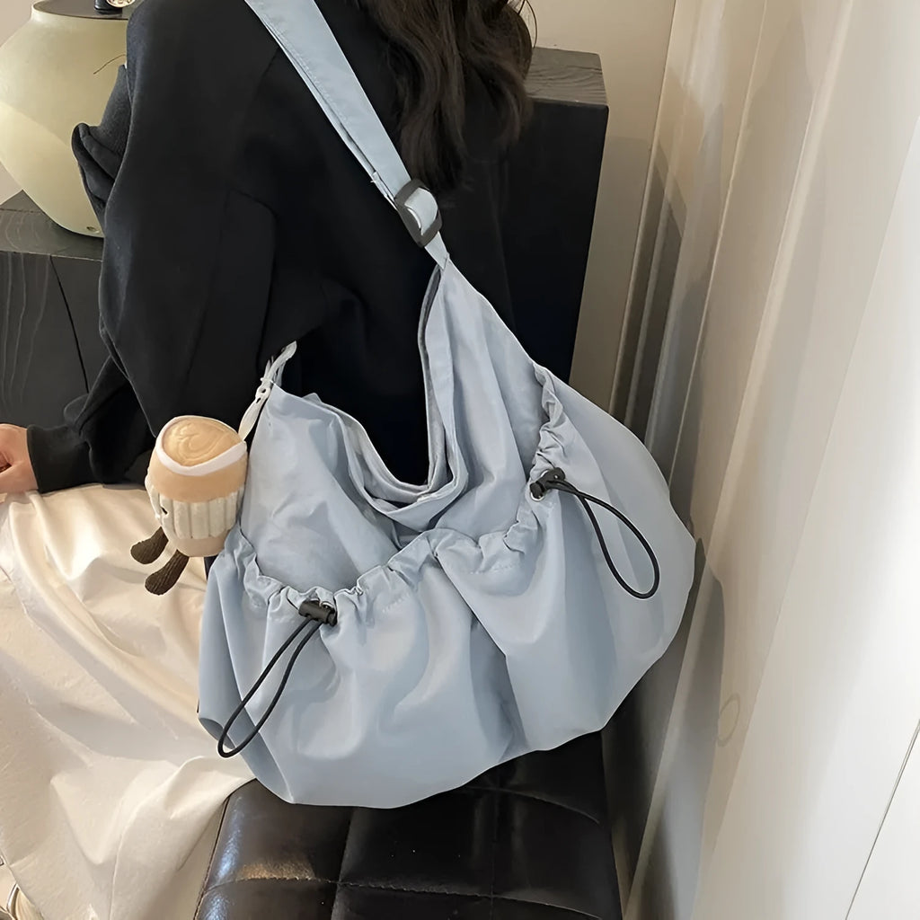 Soft green pleated polyester crossbody bag with a split pocket, shown folded and open with phone pocket visible.