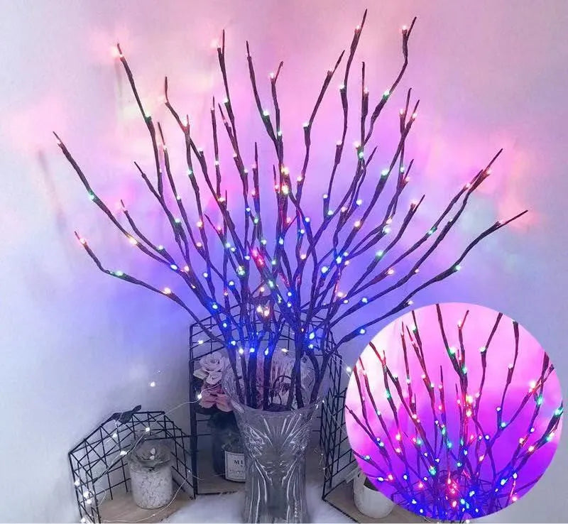 Silver branch LED tree lamp in a vase emitting warm white light, a decorative room centrepiece.
