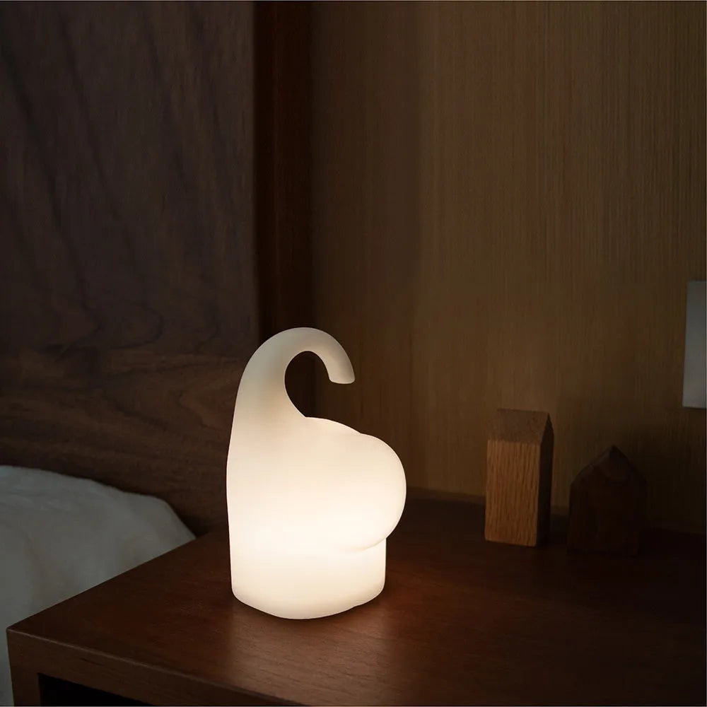 DOMI Elephant-shaped silicone night light with warm white LED glow on a bedside table.