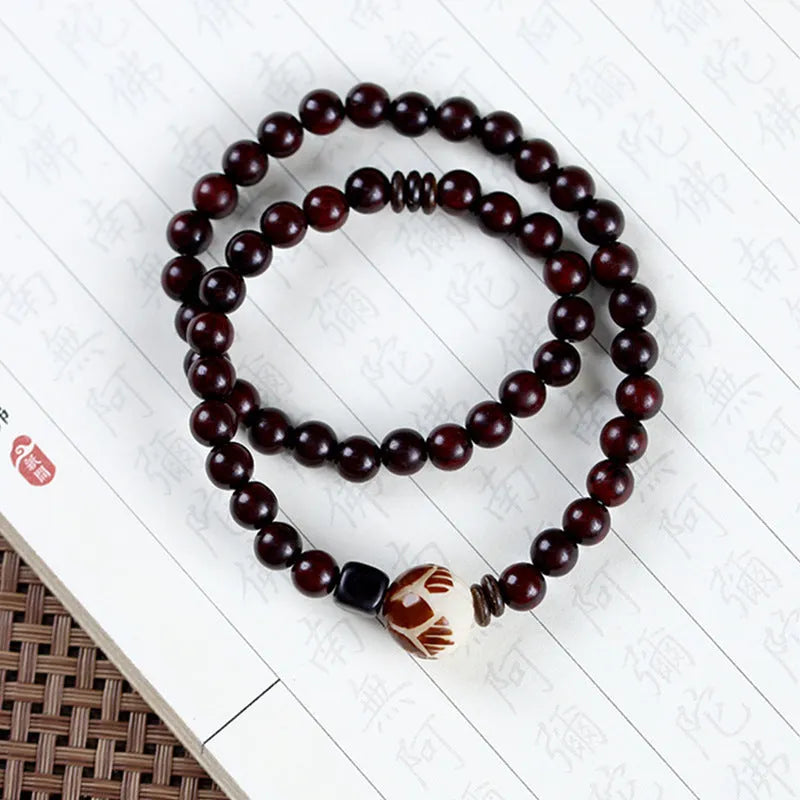 Rosewood bracelet with floral beads and circle pendant options on wooden background