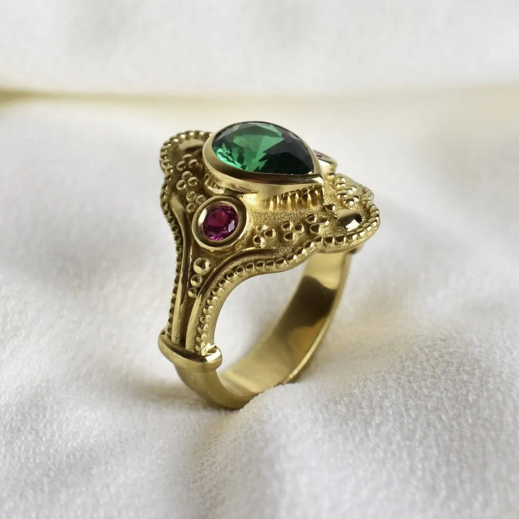 Gold-coloured geometric women's ring with an electroplated finish on a grey background.