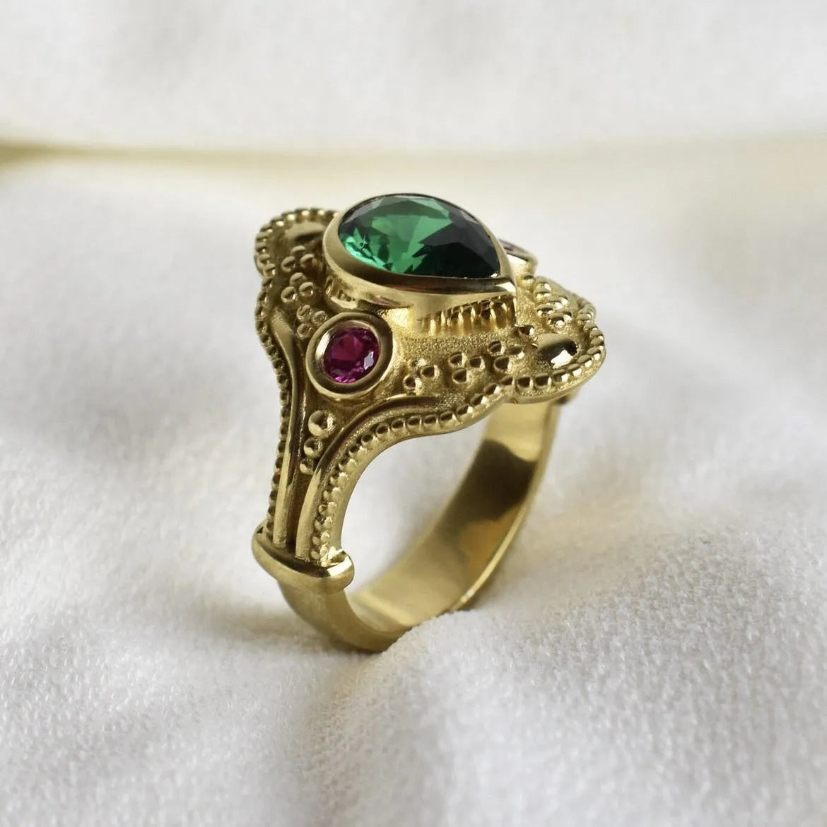 Gold-coloured geometric women's ring with an electroplated finish on a grey background.