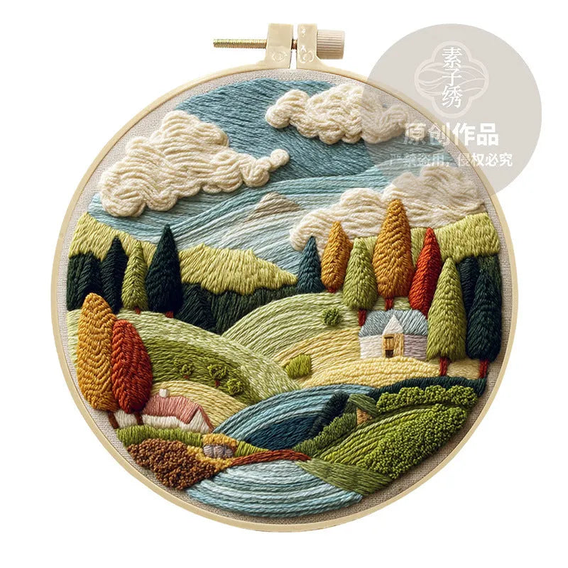DIY landscape embroidery kit with bamboo frame, printed fabric, and thread on a table