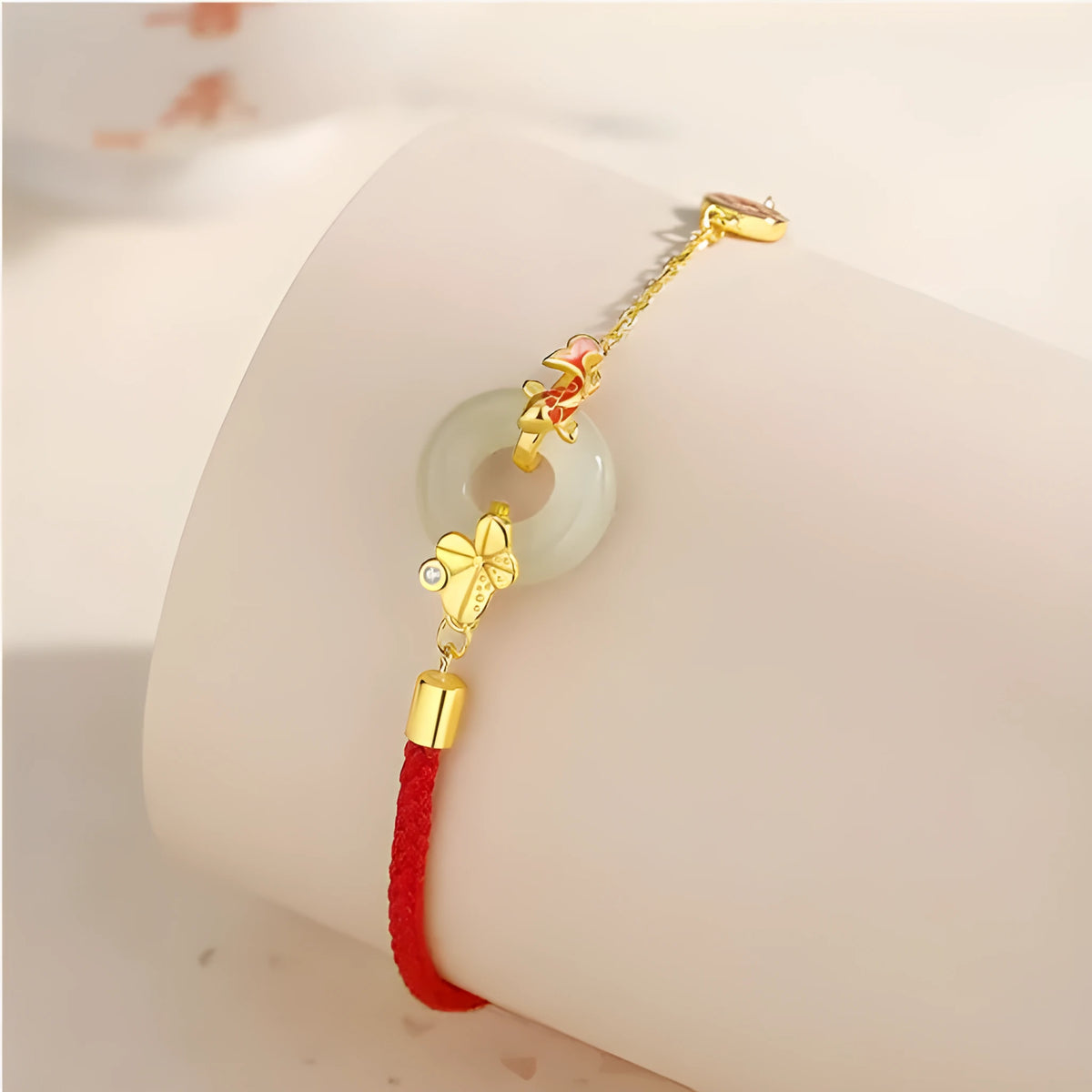 Close-up of a women's retro bracelet with a Hetian Jade stone, red cord, and a gold Koi fish safety buckle on a 925 silver chain.