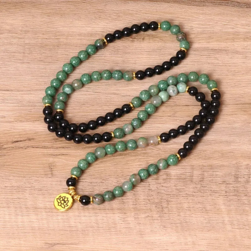 Green and black alloy beaded bracelet on an elastic cord