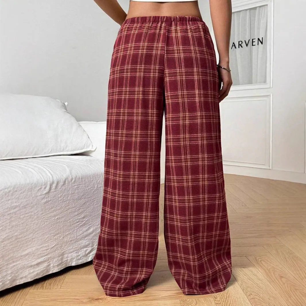 Blue loose fit women's plaid trousers with drawstring waist and pockets on a neutral background.
