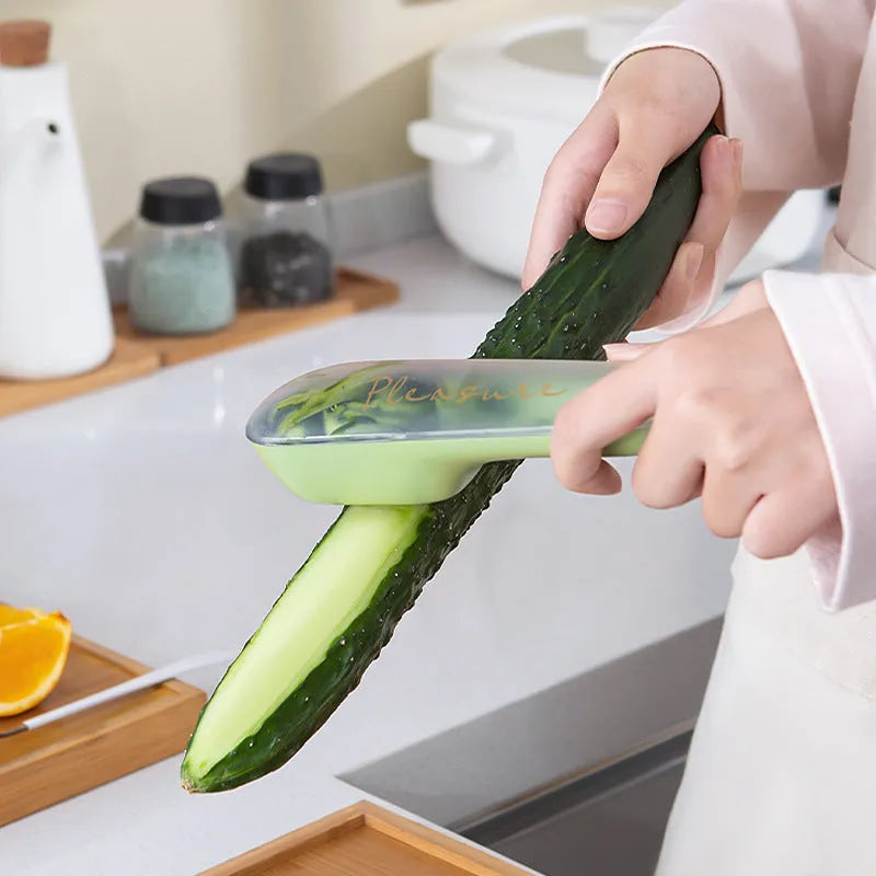 Dark green kitchen peeler with a storage tube and stainless steel blade, shown next to a potato.