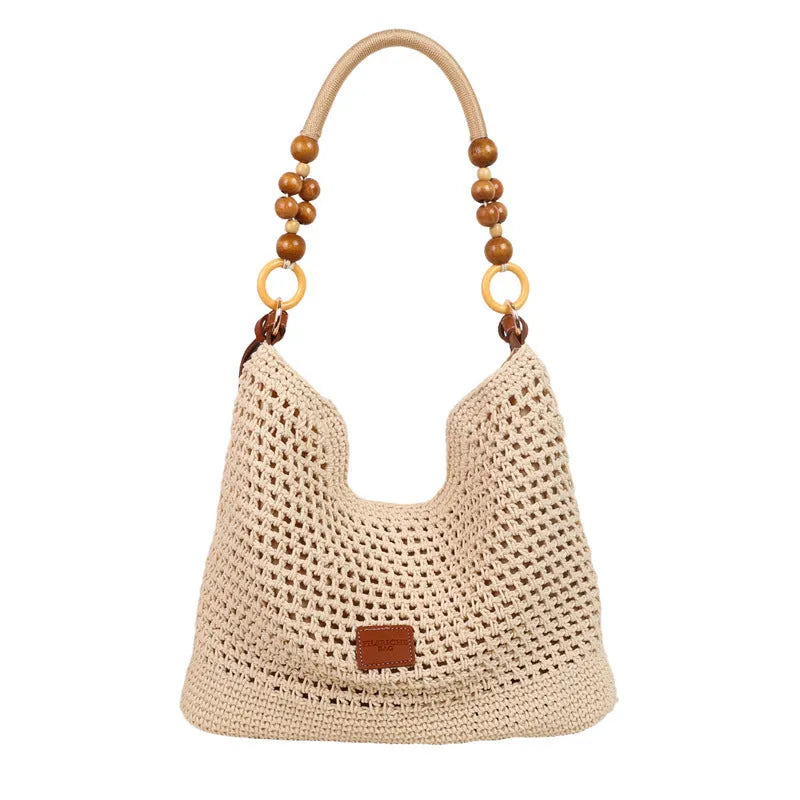 Knitted crossbody tote bag in bucket shape, shown in black with contrast stitching and a zippered internal pocket.