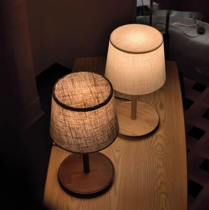 Walnut colour solid wood table lamp with a white cloth shade and a black cable switch