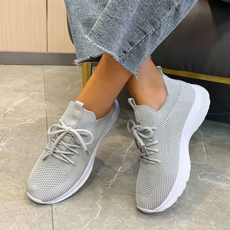Women's mesh running shoes in creamy white with Flyknit upper and round toe design