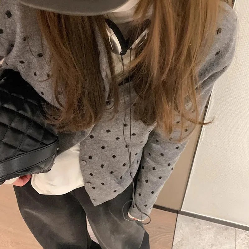 Women's grey dot knitted cardigan with crocheted flower details on sleeves, loose fit.