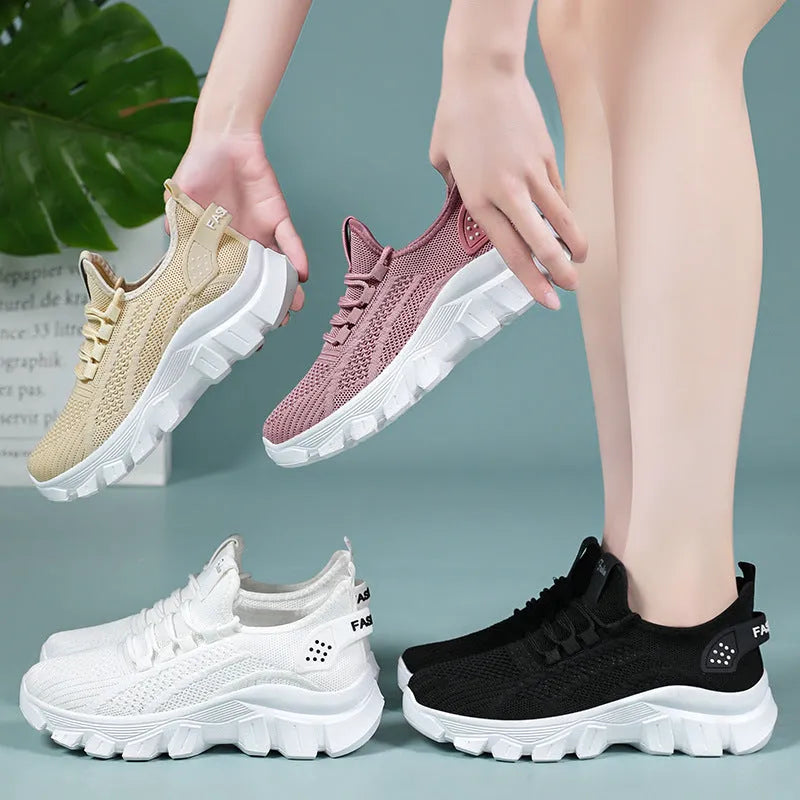 Women's white Flyknit running sneakers with lace-up front and thick PVC sole on a neutral background.