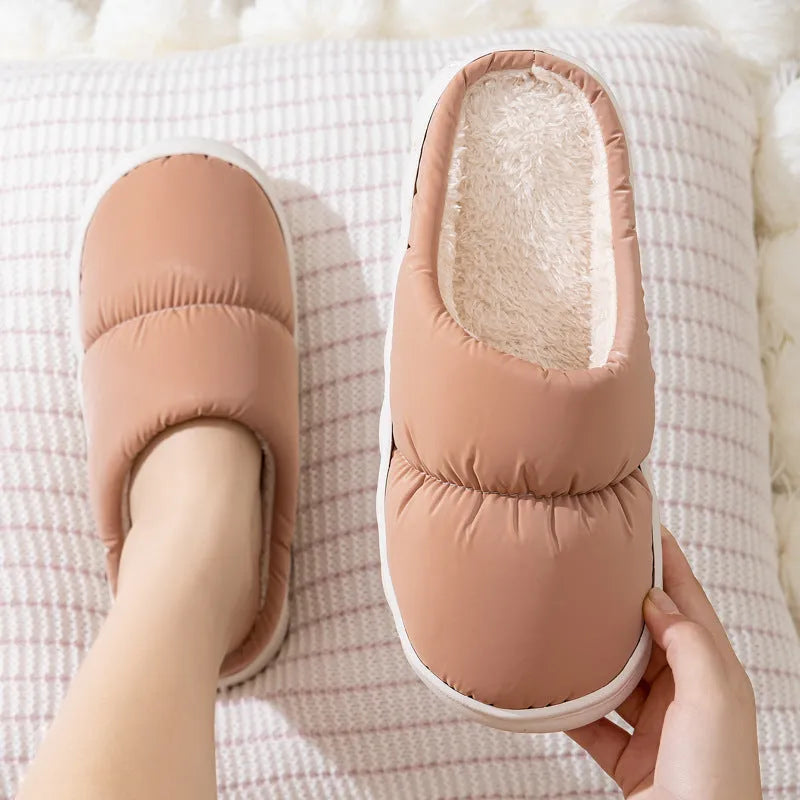 A pair of down cotton slippers with a thick rubber sole and artificial leather upper in a selected colour.