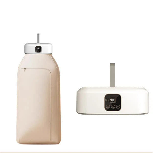 White cylindrical portable mini clothes dryer with remote control on a table.