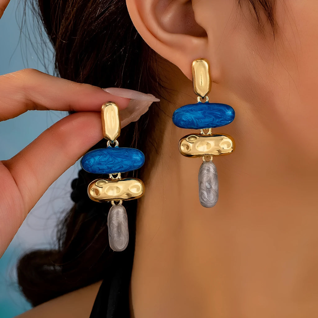 A pair of geometric stud earrings with a multicolour electroplated finish on a zinc alloy base.