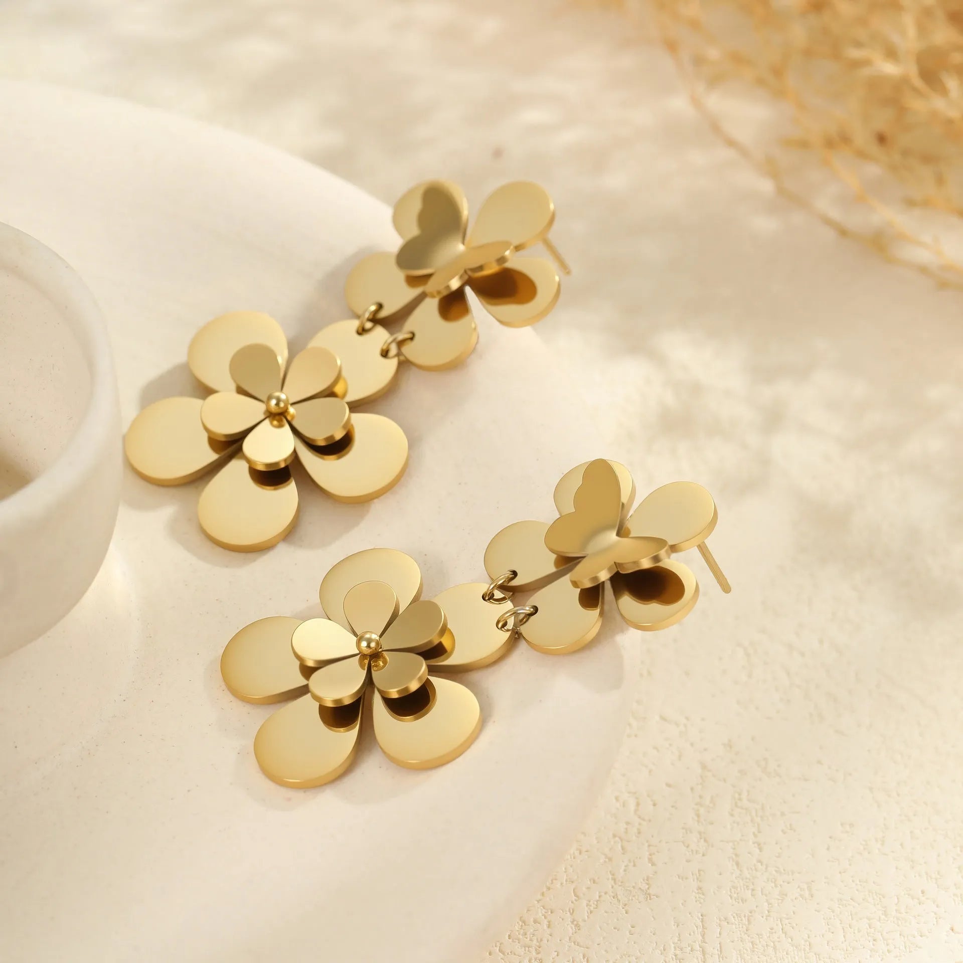 Gold coloured flower butterfly earrings with geometric and zodiac details on stainless steel.