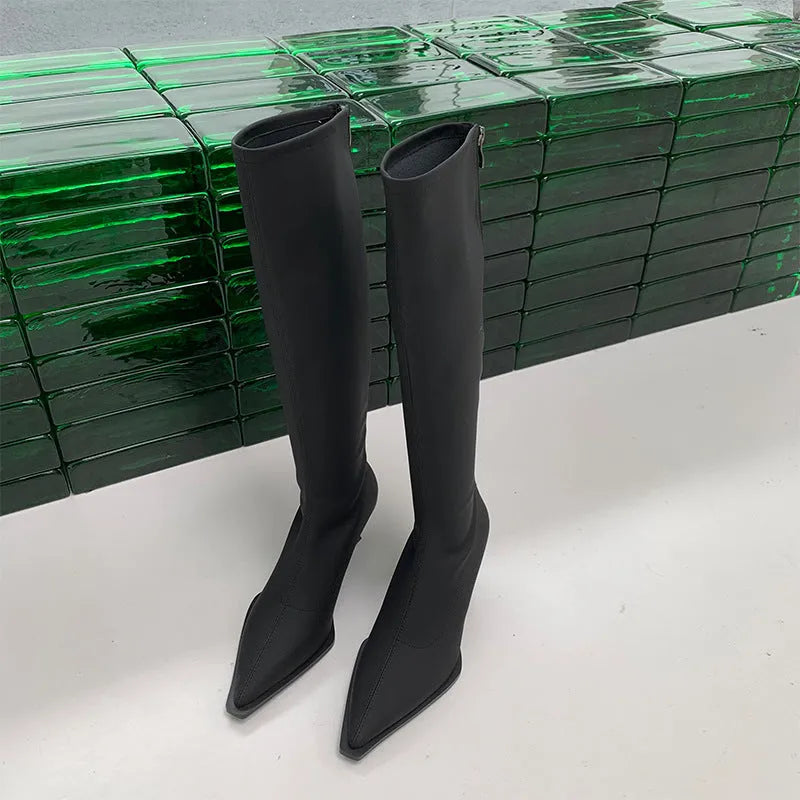 Women's black pointed toe below knee boots with back zipper and stiletto heel on grey background
