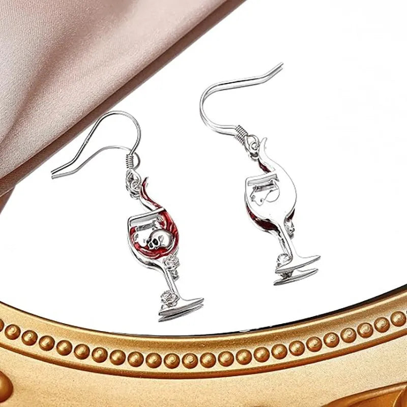 A pair of silver-toned geometric skull earrings for pierced ears on a plain background.