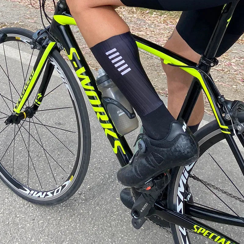 Athletic cycling and running socks in chemical fibre blend fabric, shown in orange, black, purple, white, grey or dark blue.