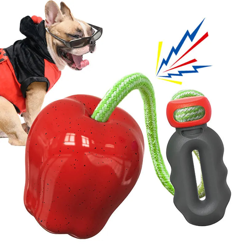 Green and red apple-shaped plastic dog toy with hollow treat-dispensing interior and squeaky sound mechanism