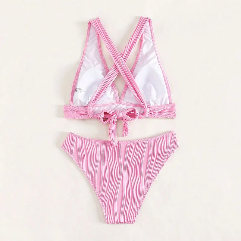 Women's black halter strap bikini with split shorts on beach background