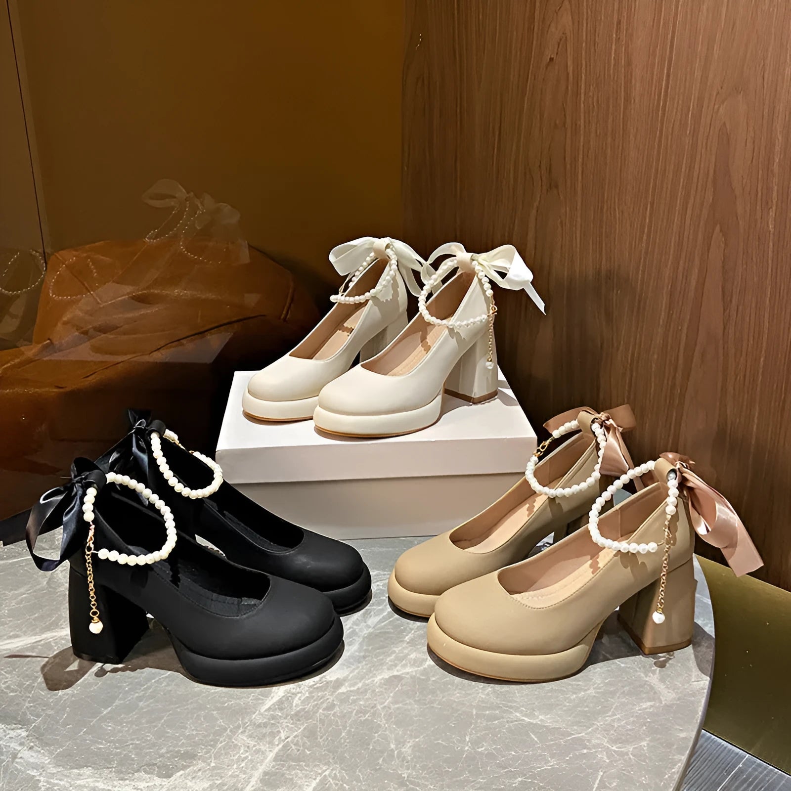 Women's beige Mary Jane shoes with a chunky heel and pearl-embellished ankle-strap buckle on a round toe.