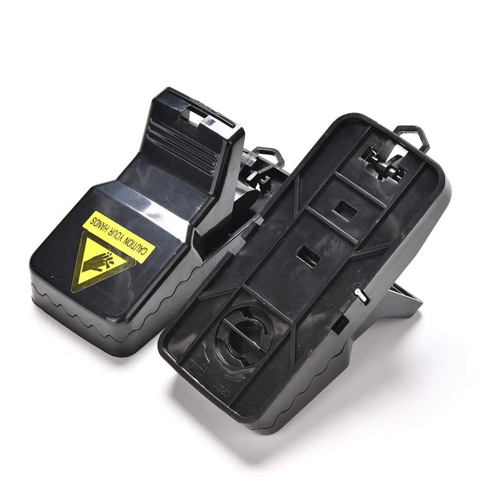 Six black plastic snapping mousetraps showing bite-trap mechanism with ruler showing 11cm length