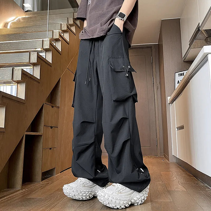 Plus size straight-leg waterproof trousers in black, grey, or white, showing drawstring waist and thin polyester fabric.