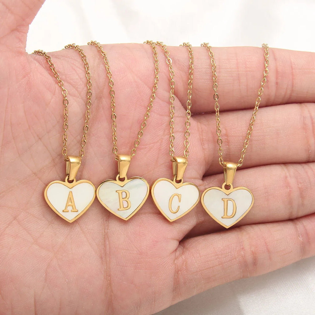 Heart-shaped letter necklace with white shell detail on gold-plated stainless steel chain