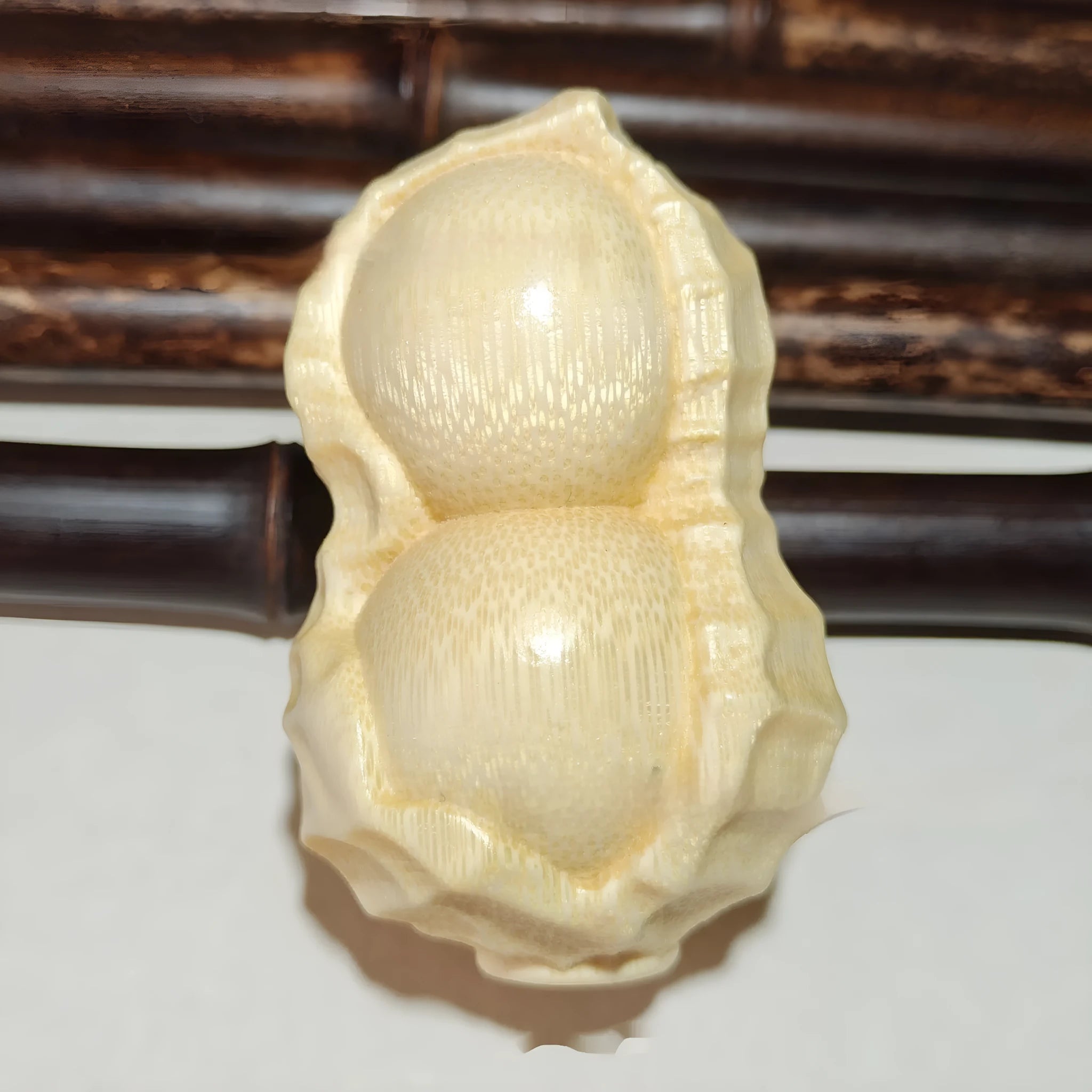 Solid bamboo peanut ornament carving on a plain background