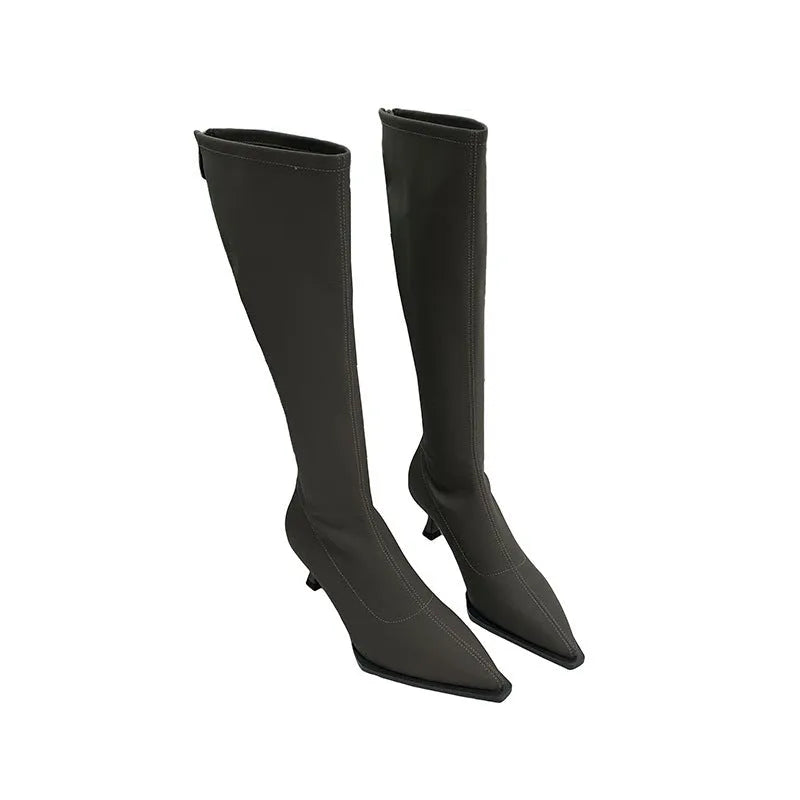 Women's black pointed toe below knee boots with back zipper and stiletto heel on grey background