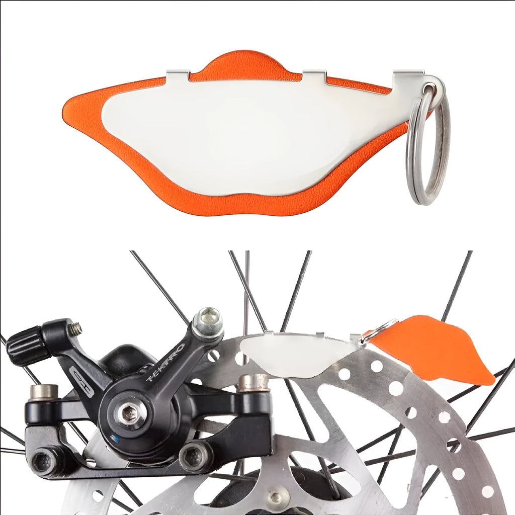 Mountain bike disc brake pads in black and orange colours with adjustment flap