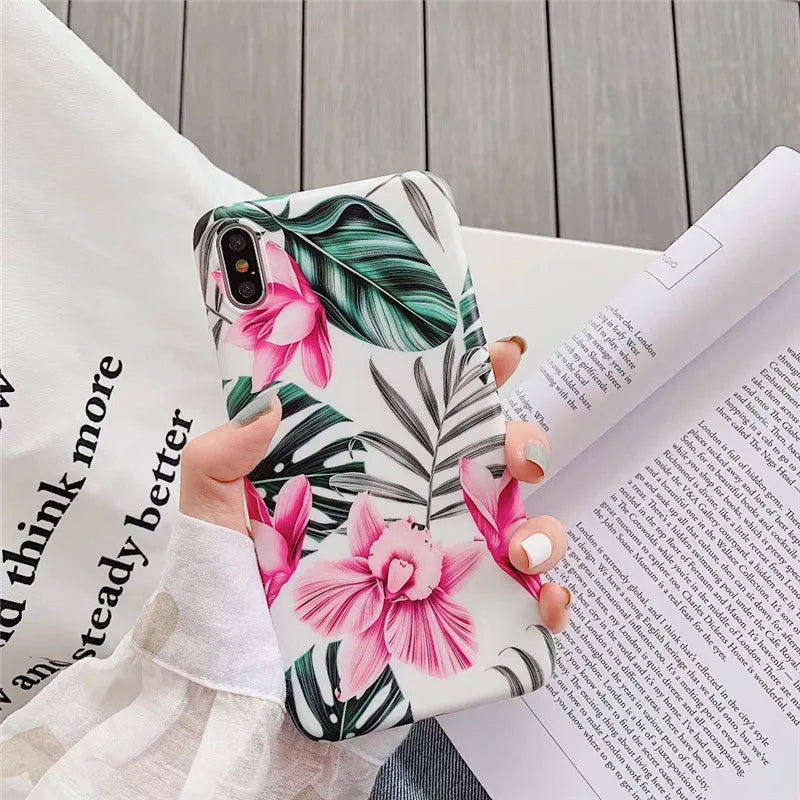 Pink floral pattern TPU back cover case for iPhone on a wooden table.