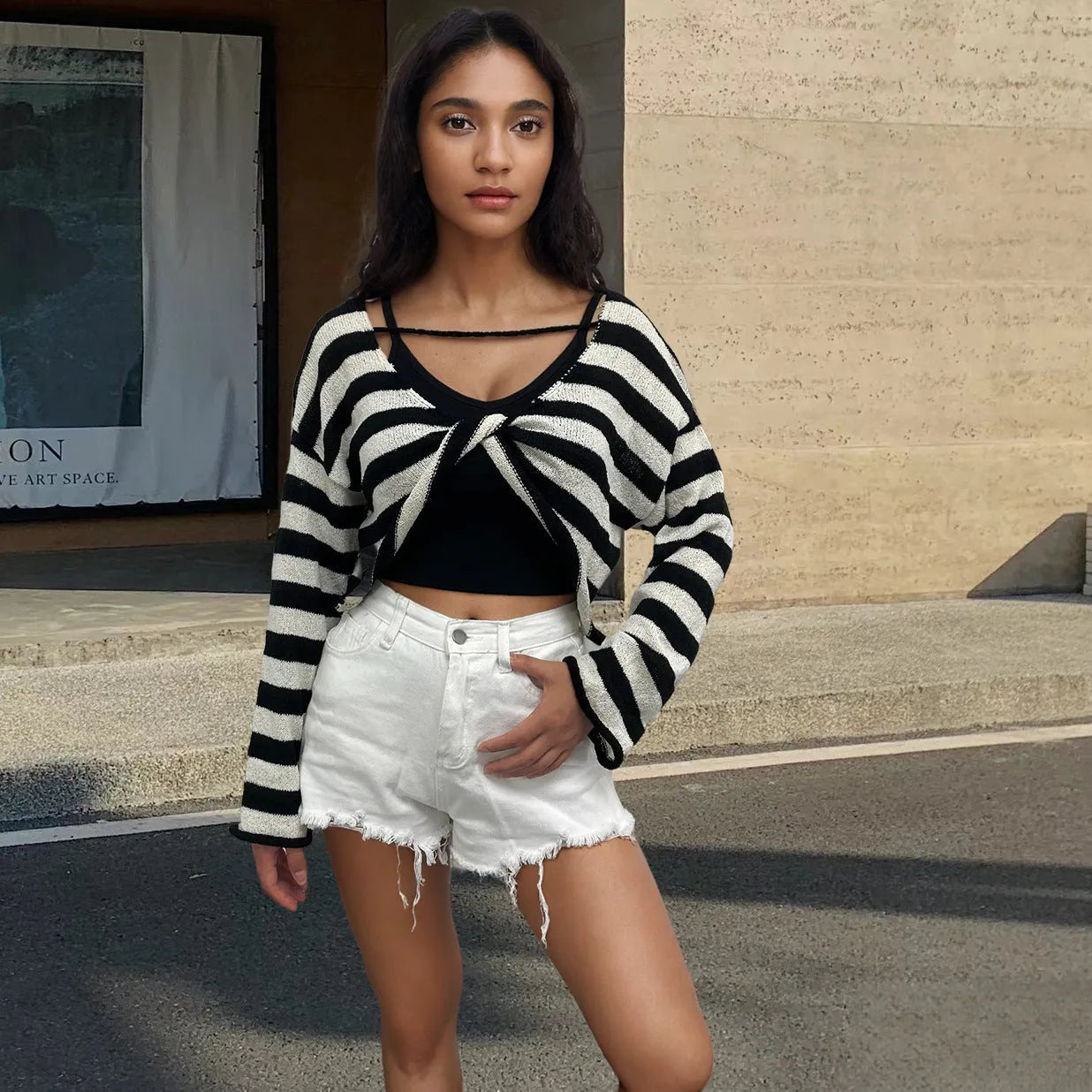 Striped long-sleeved sweater with front and back wearable design and exposed navel detail.