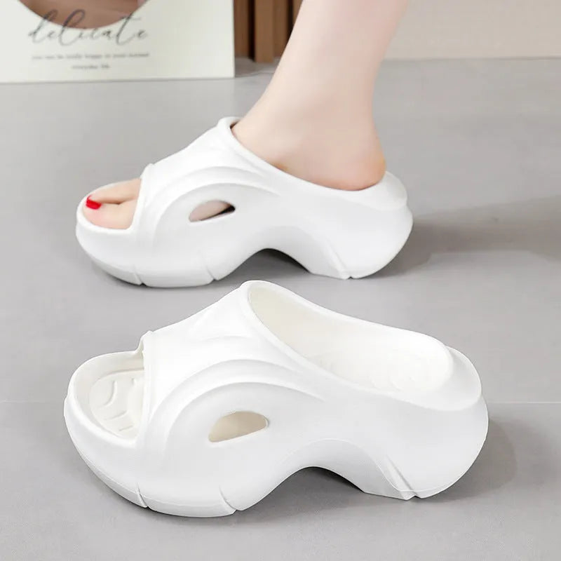 Women's white EVA slippers with thick sole and round toe on sandy beach