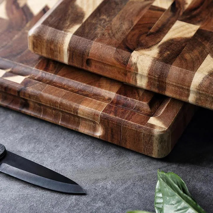 Brown acacia solid wood parquet cutting board with 3cm thickness on a kitchen counter.