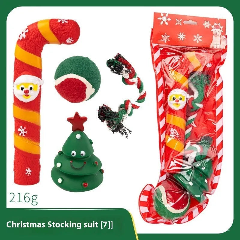 A set of red, green, and white vinyl Christmas dog toys including a Santa head, bite rope, and tennis ball.