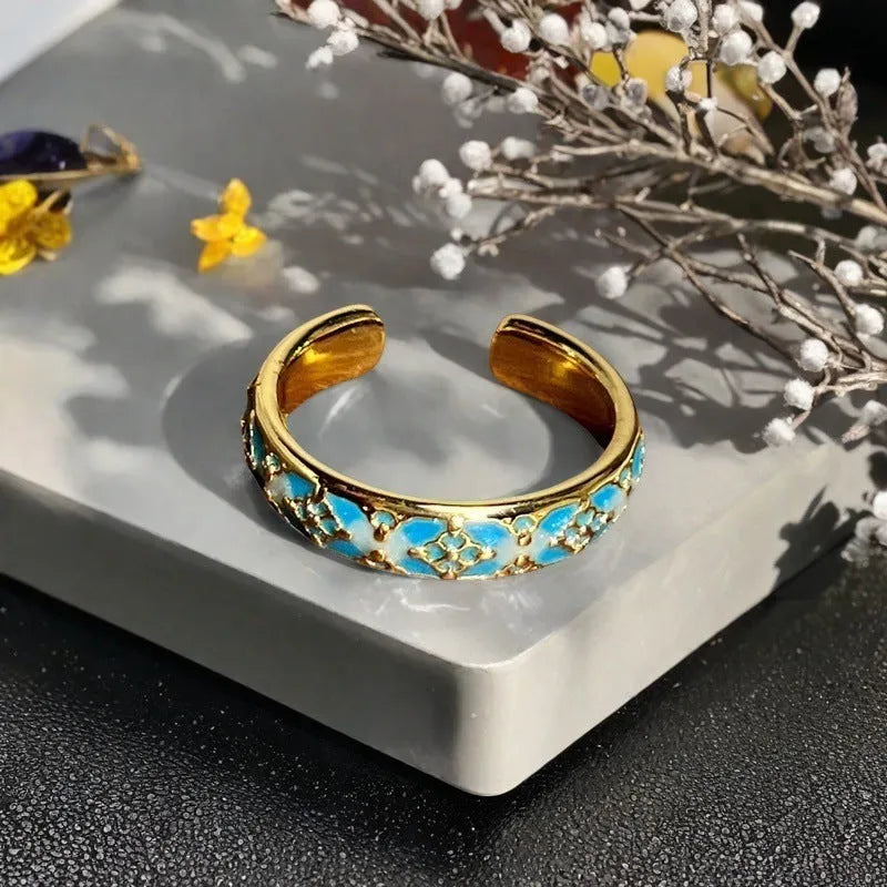 Adjustable copper ring with vintage oil dripping finish showing gourd, flower and bow design with inlaid zircon stones.