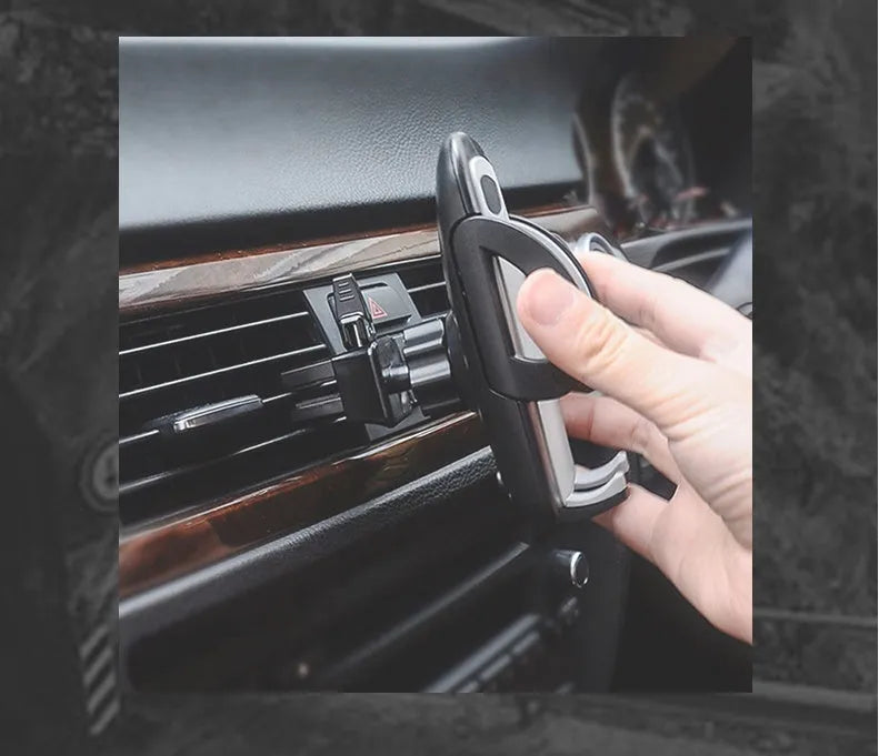 Black plastic mobile phone holder attached to car air conditioning outlet for hands-free navigation